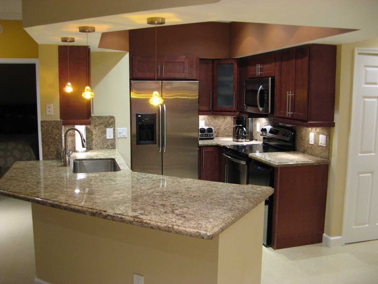 Kitchen remodeling Miami – dark wood cabinets with granite island by Active Builders